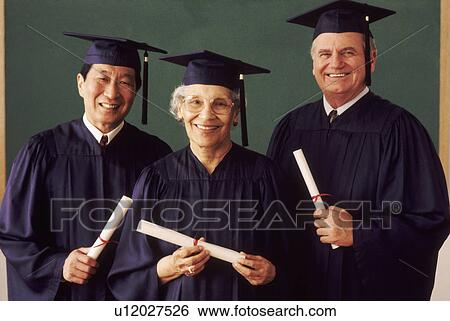 Stock Photograph - Three adult students wearing graduation gowns. Fotosearch