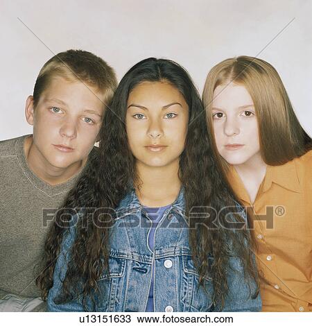 Stock Image - Three teenage friends sitting in a row. Fotosearch