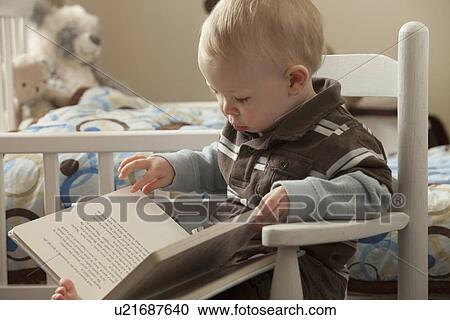 Stock Image - Toddler looking at a book. Fotosearch