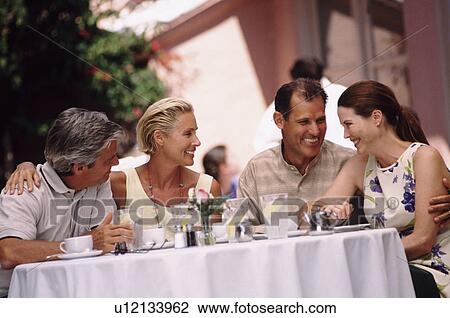 Two couples having dinner on the patio of a restaurant View Large Photo Image Stock Image - Two couples having dinner on the patio of a restaurant. Fotosearch