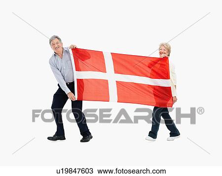 Stock Image - Two people carry the Danish flag. Fotosearch