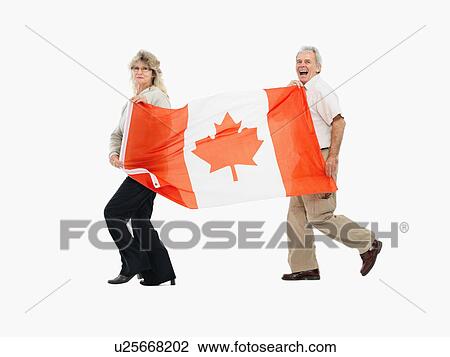Two people carrying the Canadian flag View Large Photo Image Stock Image - Two people carrying the Canadian flag. Fotosearch
