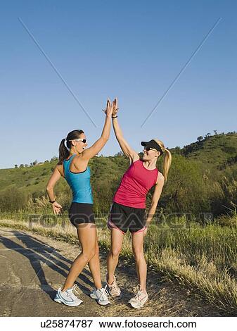 Two trail runners giving each other a high five View Large Photo Image Stock Photo - Two trail runners giving each other a high five. Fotosearch