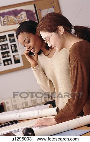 Two woman working in architect's office View Large Photo Image Stock Image - Two woman working in architect's office. Fotosearch