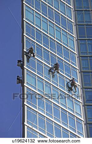 Stock Image - Window washers cleaning windows on skyscraper. Fotosearch