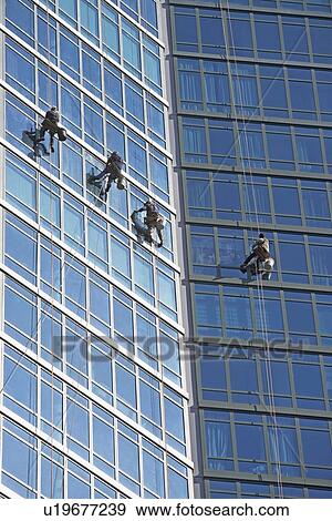 Stock Photo - Window washers cleaning windows on skyscraper. Fotosearch