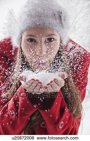 Stock Photo - Woman blowing snow off her hands. Fotosearch