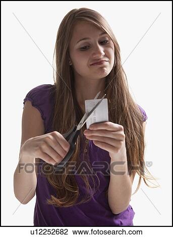 Stock Image - Woman cutting up a credit card. Fotosearch