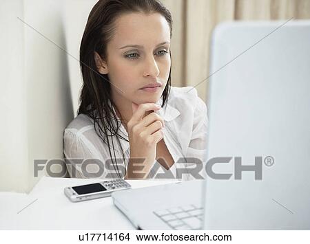 Woman deep in thought while looking at laptop View Large Photo Image Picture - Woman deep in thought while looking at laptop. Fotosearch