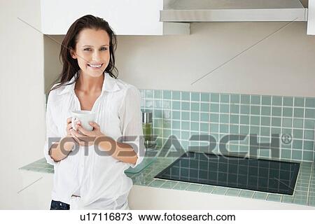 Woman drinking coffee in kitchen View Large Photo Image Stock Image - Woman drinking coffee in kitchen. Fotosearch