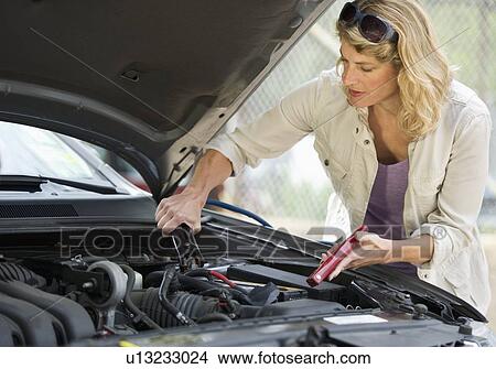 Woman fixing car View Large Photo Image Picture - Woman fixing car. Fotosearch