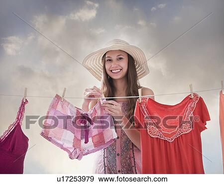 Woman hanging laundry on clothesline View Large Photo Image Stock Photo - Woman hanging laundry on clothesline. Fotosearch