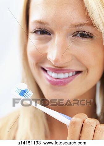 Stock Image - Woman holding a toothbrush. Fotosearch