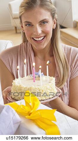 Stock Photograph - Woman holding birthday cake. Fotosearch