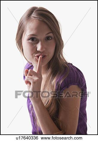 Stock Photograph - Woman holding her finger in front of her lips. Fotosearch