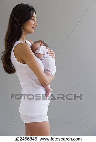 Woman holding her newborn baby View Large Photo Image Stock Photography - Woman holding her newborn baby. Fotosearch