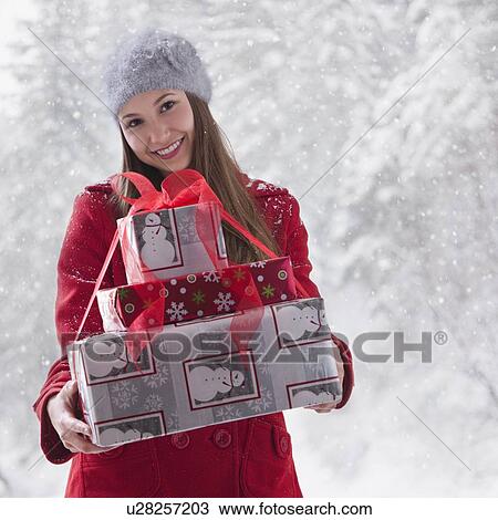 Stock Image - Woman holding stack of Christmas presents. Fotosearch