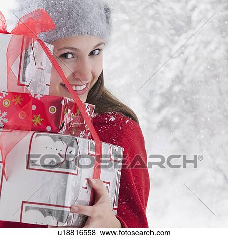 Stock Photo - Woman holding stack of Christmas presents. Fotosearch