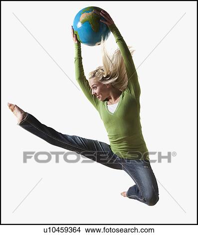 Woman jumping in air while holding globe View Large Photo Image Picture - Woman jumping in air while holding globe. Fotosearch