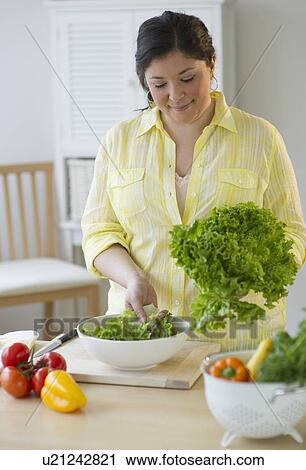 Stock Image - Woman preparing a salad. Fotosearch
