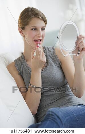 Woman putting on lipstick View Large Photo Image Stock Image - Woman putting on lipstick. Fotosearch