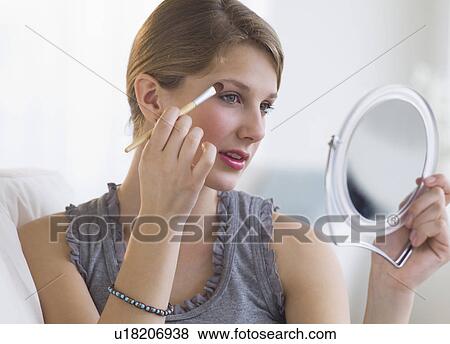 Woman putting on makeup View Large Photo Image Stock Photo - Woman putting on makeup. Fotosearch