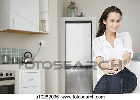 Woman relaxing in kitchen View Large Photo Image Stock Photograph - Woman relaxing in kitchen. Fotosearch
