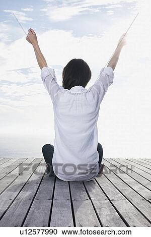 Woman sitting on porch with her arms raised View Large Photo Image Stock Image - Woman sitting on porch with her arms raised. Fotosearch