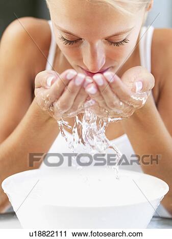 Stock Image - Woman splashing water on her face. Fotosearch