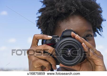 Stock Photo - Woman taking picture with a digital camera. Fotosearch