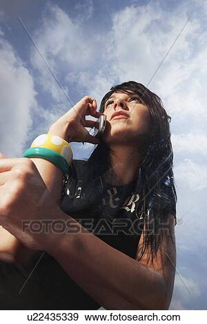 Stock Photo - Woman talking on cell phone outdoors. Fotosearch