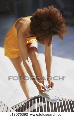 Woman tying her shoelace View Large Photo Image Stock Image - Woman tying her shoelace. Fotosearch