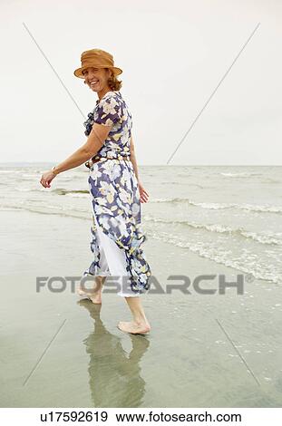 Woman walking on the beach View Large Photo Image Stock Photo - Woman walking on the beach. Fotosearch