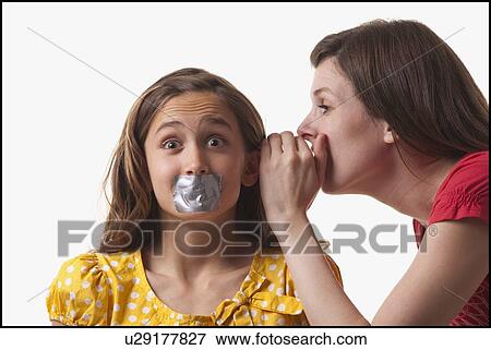 Woman whispering to a frightened girl View Large Photo Image Stock Photo - Woman whispering to a frightened girl. Fotosearch