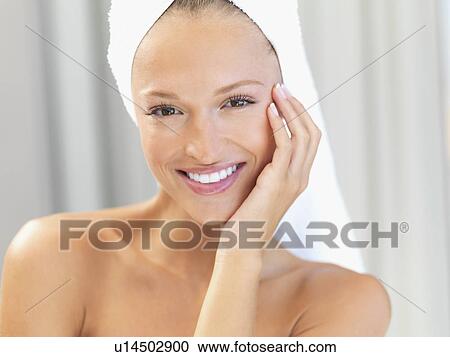 Stock Image - Woman with a towel wrapped around her head. Fotosearch