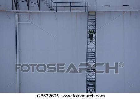 Worker walking down stairs on an oil tank View Large Photo Image Stock Photography - Worker walking down stairs on an oil tank. Fotosearch