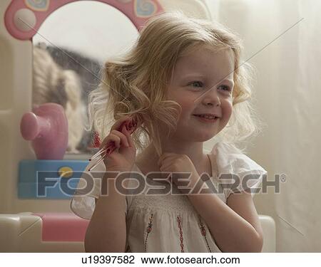 Young girl combing her hair View Large Photo Image Stock Image - Young girl combing her hair. Fotosearch