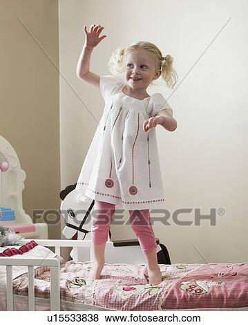 Young girl dancing on her bed View Large Photo Image Stock Photo - Young girl dancing on her bed. Fotosearch