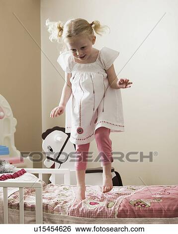 Young girl dancing on her bed View Large Photo Image Stock Photograph - Young girl dancing on her bed. Fotosearch