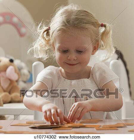 Stock Image - Young girl playing memory game. Fotosearch