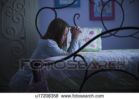 Stock Photo - Young girl praying before bed. Fotosearch