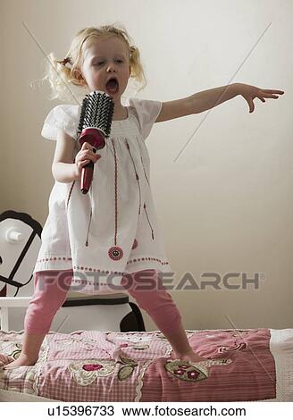 Young girl singing on her bed View Large Photo Image Stock Image - Young girl singing on her bed. Fotosearch