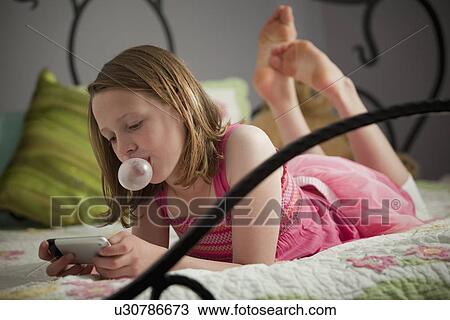 Stock Image - Young girl texting. Fotosearch