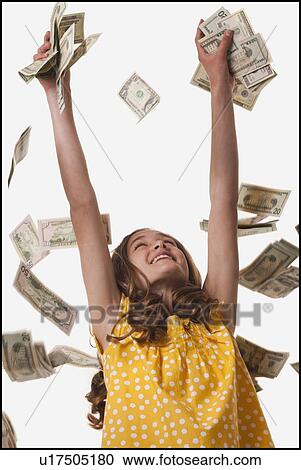 Stock Image - Young girl throwing money in the air. Fotosearch