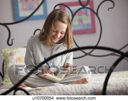 Picture - Young girl writing in her diary. Fotosearch