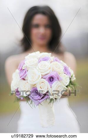 Stock Photo - A Bride Holding Her Bouquet Of Roses. Fotosearch