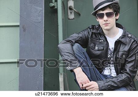 Stock Photograph - a teenage boy sitting on the back of a train; portland, oregon, united states of america. Fotosearch