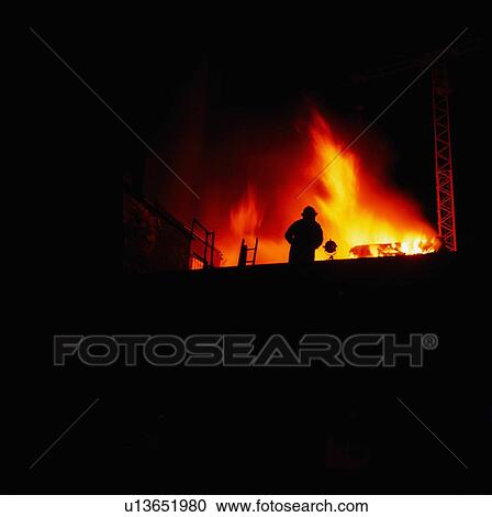 Stock Image - Firefighter Fighting Large Fire. Fotosearch