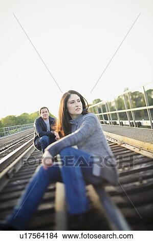 Picture - Hamilton, Ontario, Canada; A Couple Sitting On The Railroad Tracks. Fotosearch