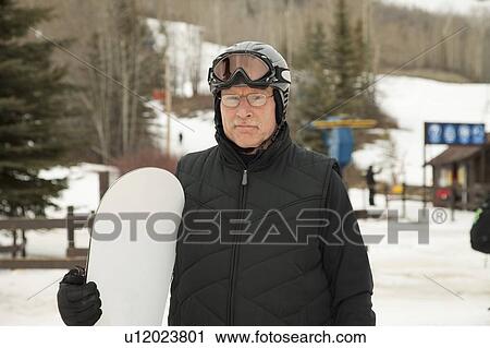 red deer, alberta, canada; a man holding a snowboard wearing a helmet and mask View Large Photo Image Stock Image - red deer, alberta, canada; a man holding a snowboard wearing a helmet and mask. Fotosearch